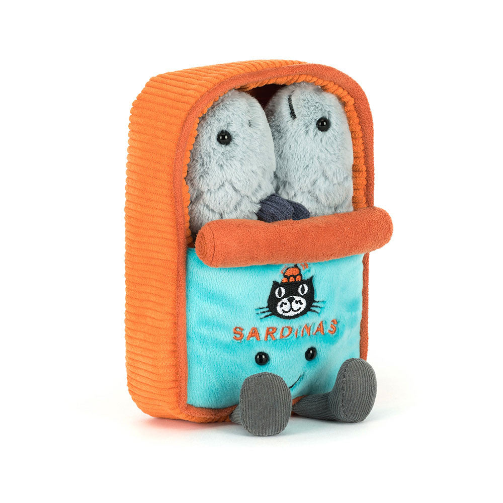 A plush toy shaped like a small orange and turquoise sardine can, with two gray fish characters peeking out from the top. The front panel is turquoise with an embroidered black cat wearing an orange hat and the word 'SARDINAS' in orange.