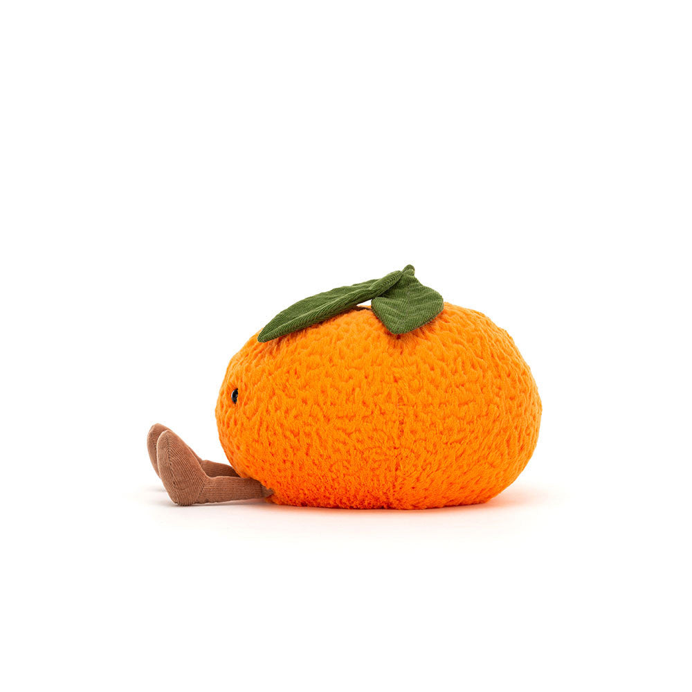 Knitted toy resembling an orange with a green leaf on a white background