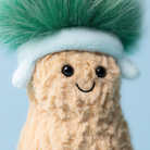 Plush toy with a green mohawk and blue headband on a light blue background