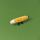 Plush toy pencil with a smiling face on a green background