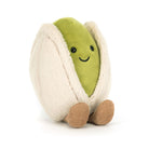 A plush avocado toy with a bright green face and body, partially wrapped in a cream-colored fuzzy shell, with small tan corduroy feet, photographed on a clean white background.