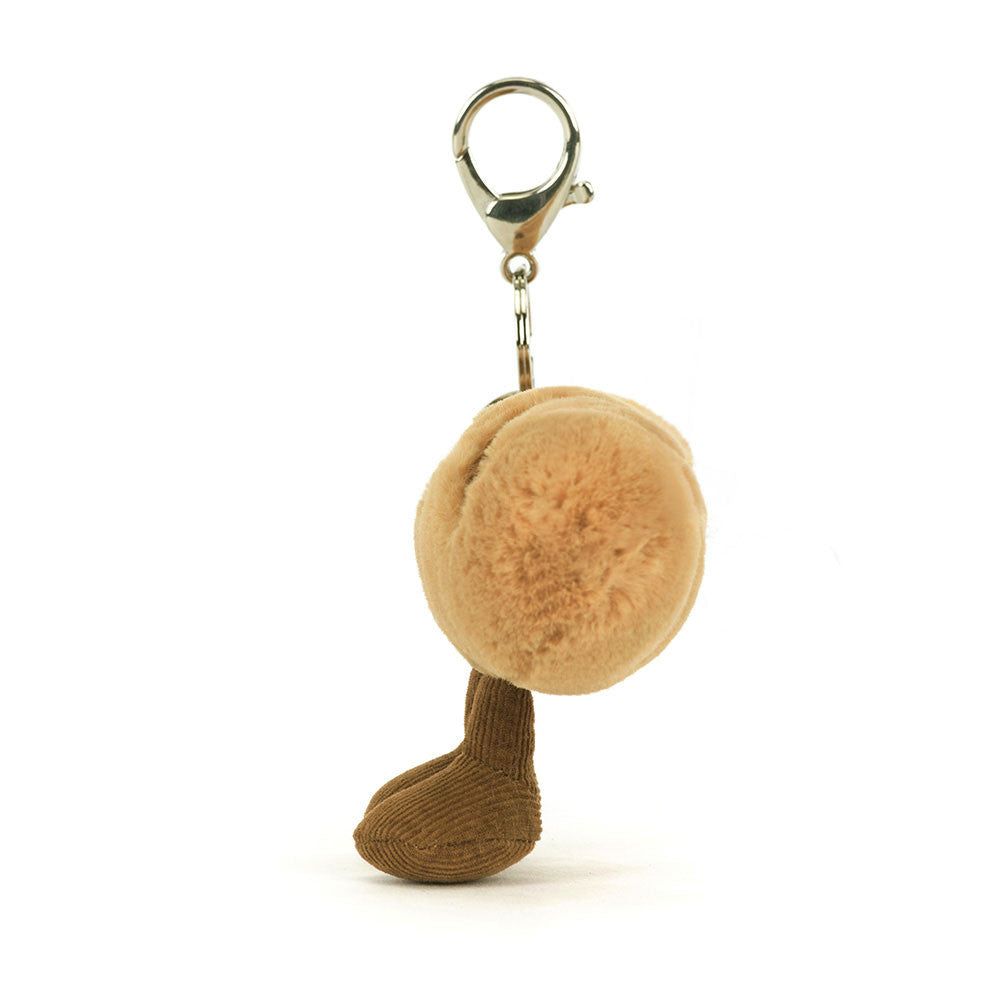 Plush keychain with a round beige ball and brown sock-like bottom on a white background