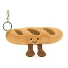 Plush baguette keychain with a smiling face on a white background