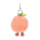 Peach-shaped keychain with legs and a leaf on a white background