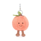 Plush peach keychain with a smiling face on a white background