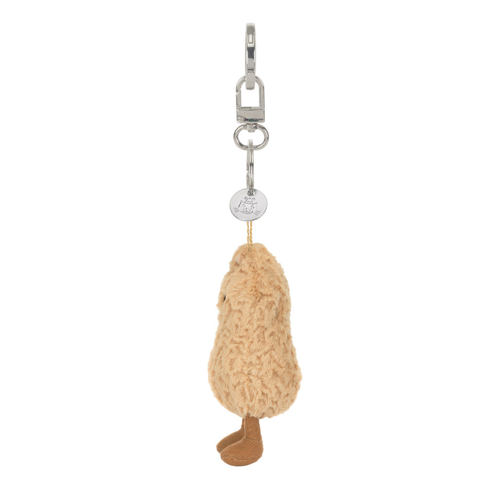 A  plush peanut-shaped keychain with a smiling face, textured beige body, brown feet and white background.