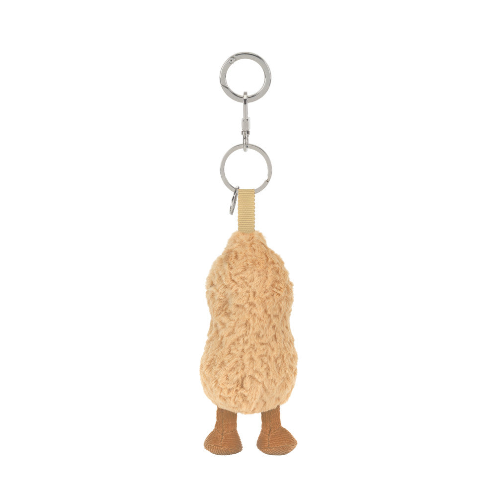 A  plush peanut-shaped keychain with a smiling face, textured beige body, brown feet.