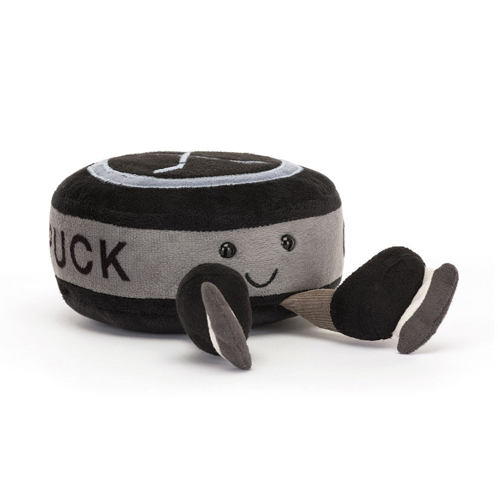 Plush toy resembling a hockey puck with a smiling face on a white background