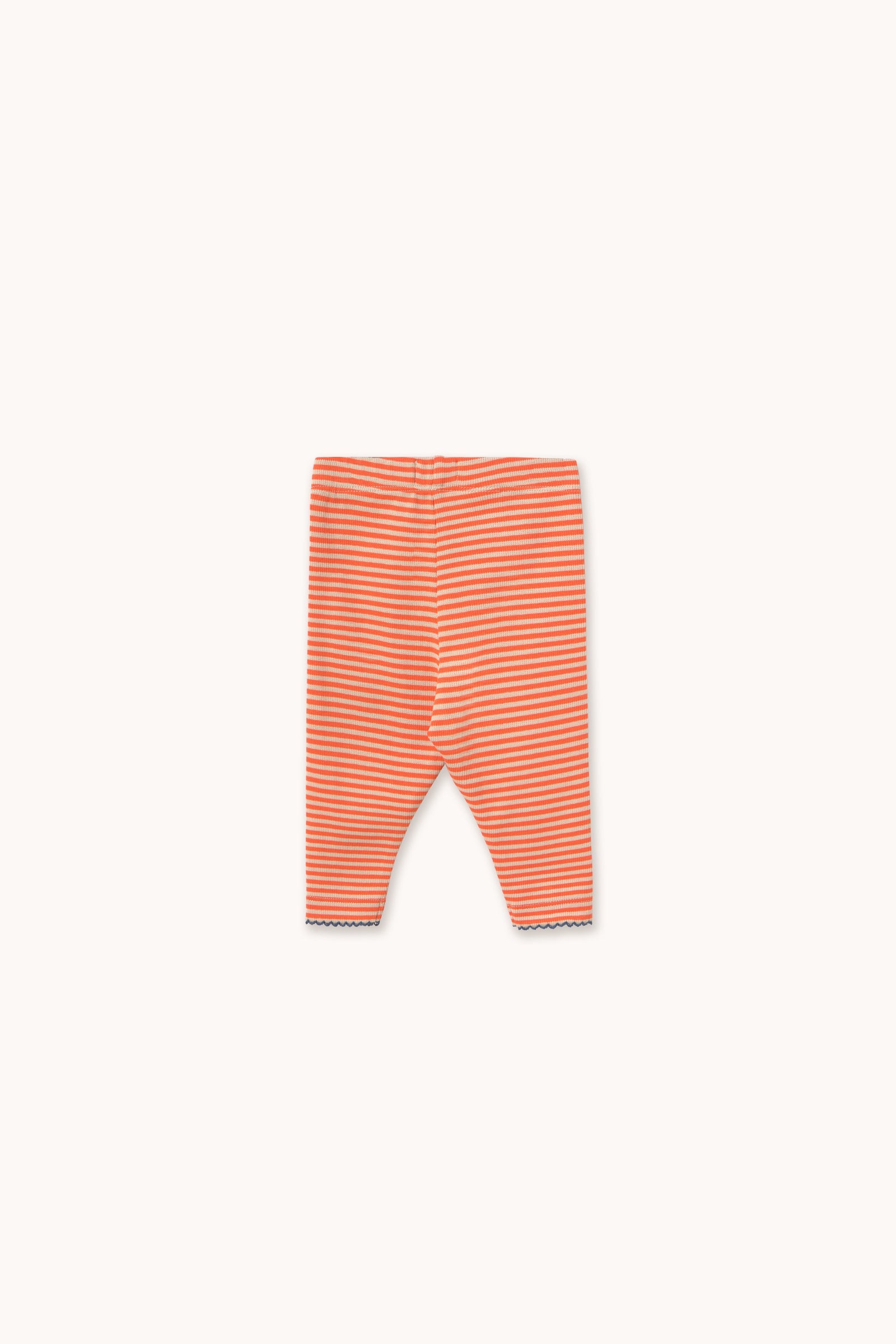 A pair of infant leggings with thin horizontal orange and white stripes, laid flat against a solid off-white background.