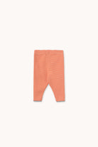 A pair of infant leggings with thin horizontal orange and white stripes, laid flat against a solid off-white background.
