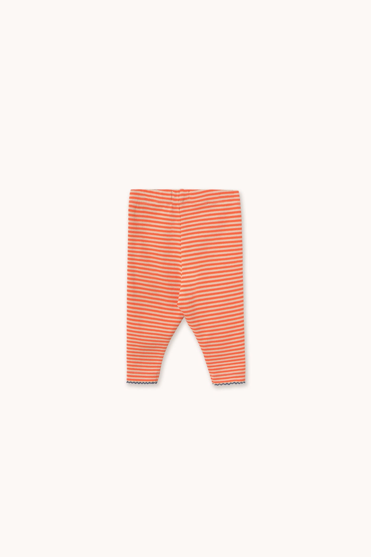 A pair of infant leggings with thin horizontal orange and white stripes, laid flat against a solid off-white background.