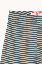 Close-up of striped knit bottoms with a white waistband and a small red TINY brand label.