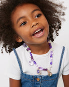 Child wearing a colorful necklace with a white background