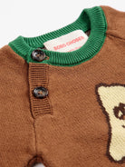 Close-up of a brown knit sweater with a green ribbed collar, two dark buttons, and a visible BOBO CHOSES neck label.