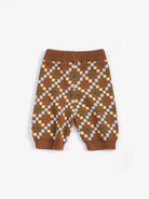 A pair of baby knit pants in brown with a geometric diamond pattern in light blue, beige, and green, featuring an elastic waistband and ribbed ankle cuffs, shown flat on a white background.