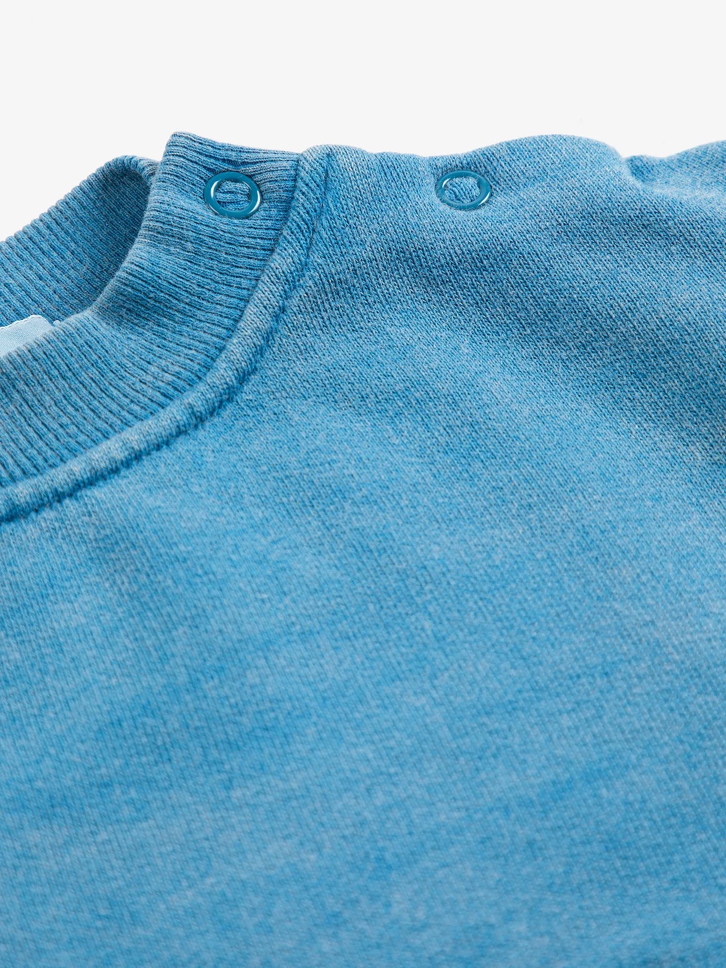 Close-up of a blue sweater with a ribbed neckline.