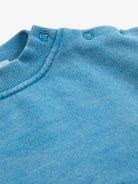 Close-up of a blue sweater with a ribbed neckline.