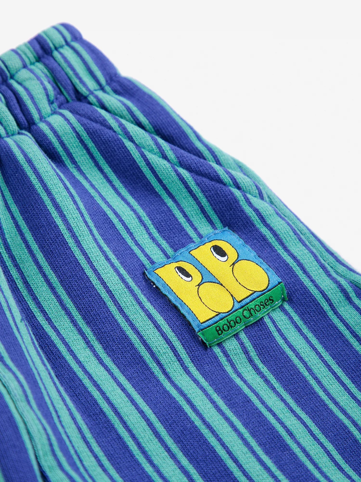 Close-up of blue and green striped pants with a logo on a white background