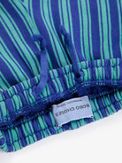 Close-up of a blue and green striped garment with a label on a white background