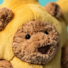 Close-up of a teddy bear with a yellow body and brown face.