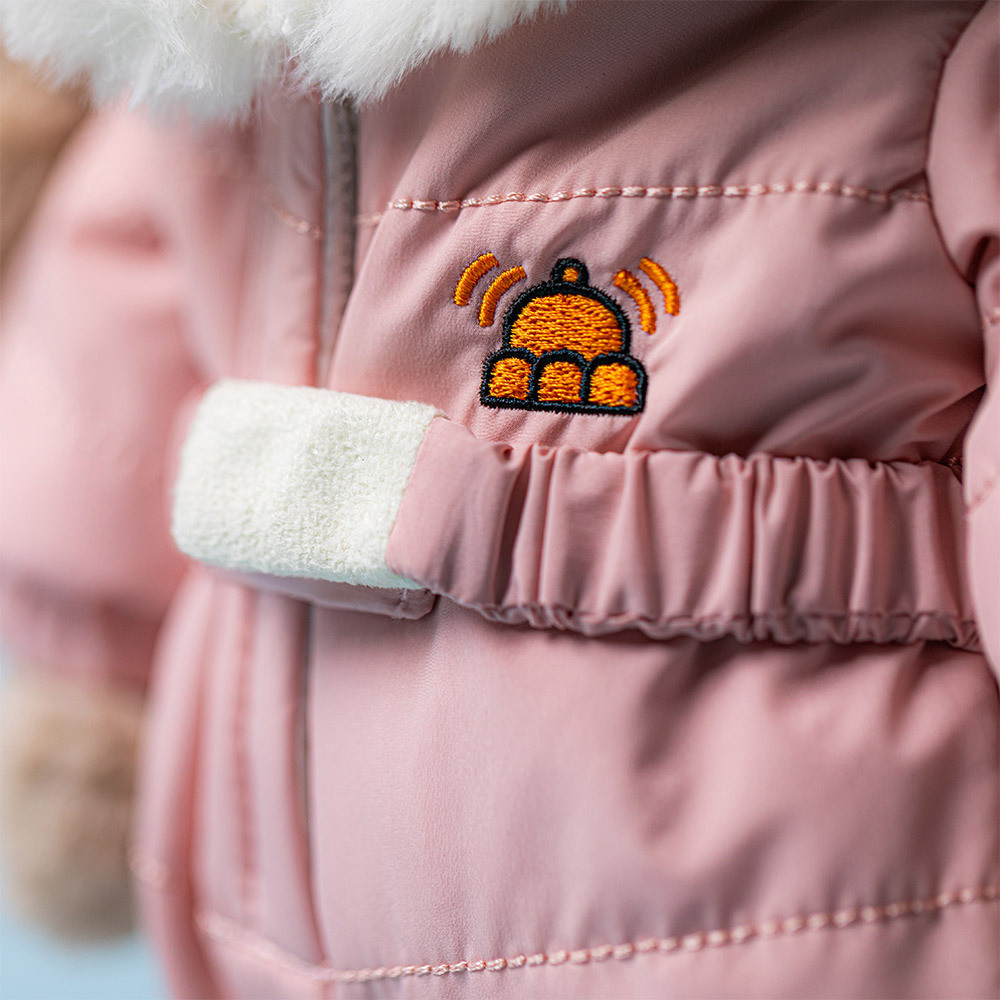 Pink children's jacket with a cartoon-like badge on the chest.