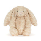 A plush stuffed bunny toy in a light cream-beige color with long floppy ears, black bead eyes, and a small pink stitched nose, photographed on a clean white background.