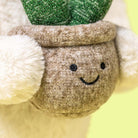 Close-up of a plush toy with a smiling face and green top hat.