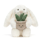 Plush toy rabbit holding a potted plant on a white background