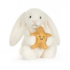 A white plush bunny plush toy holding a yellow embroidered star pillow with a smiling face, photographed on a clean white background.