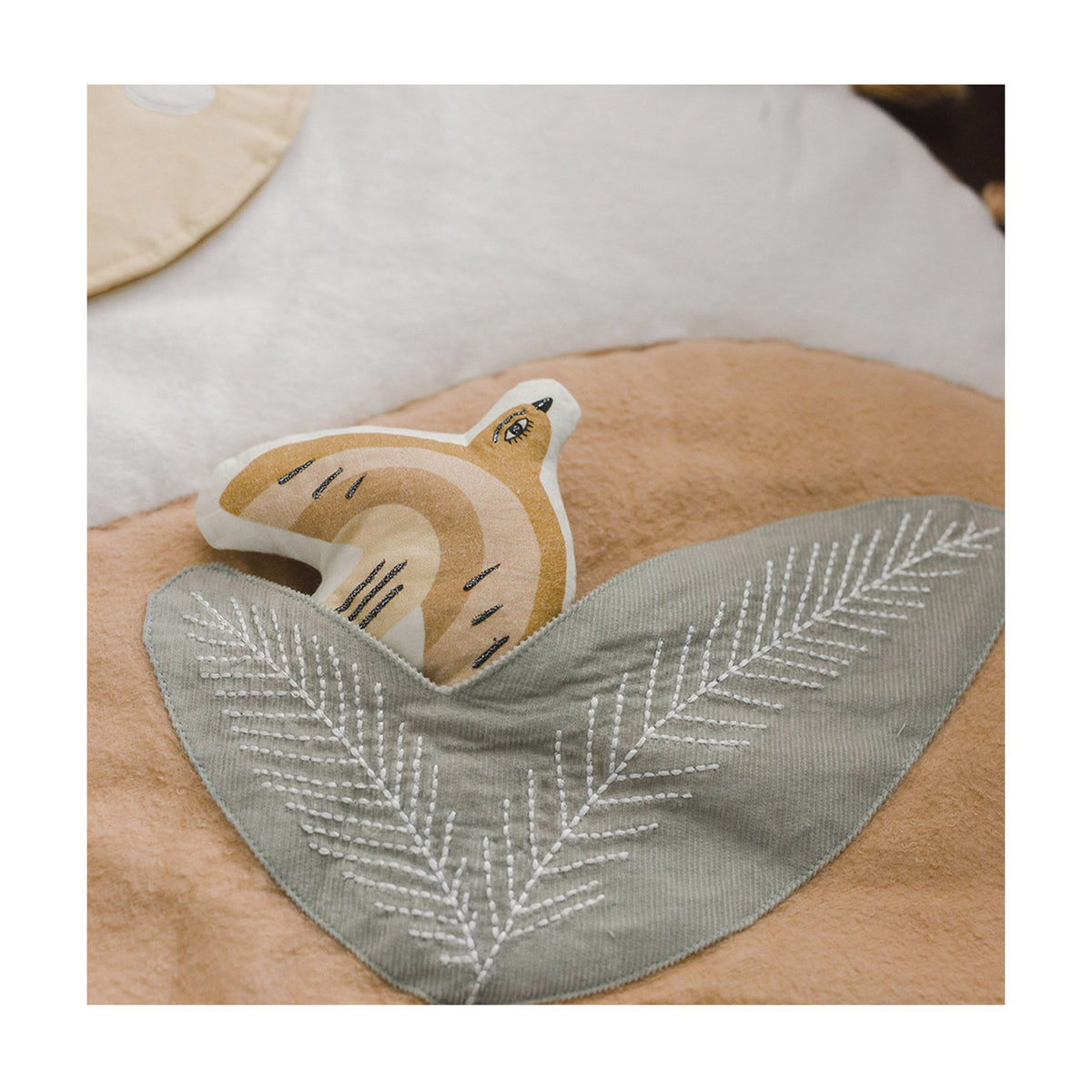 Baby bib and blanket set with fox design on a wooden surface