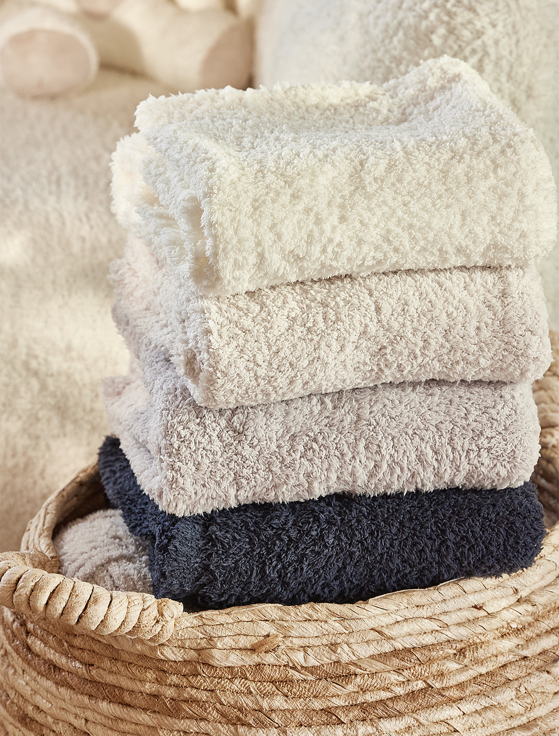 Stack of folded towels in a woven basket with a soft, blurred background