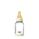 A clear glass baby bottle with a white base and a yellow latex nipple, branded with 'BIBS'.