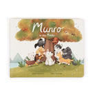 The front cover of the children's board book 'Munro in the Middle' by Steve Smallman and Miki Butterley, featuring a whimsical illustration of various cute animals gathered under a large tree.