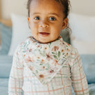 Baby wearing a floral bib with a blurred background