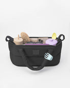 Black organizer bag with various items on a white background