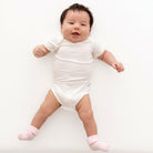Baby in a white onesie on a white background