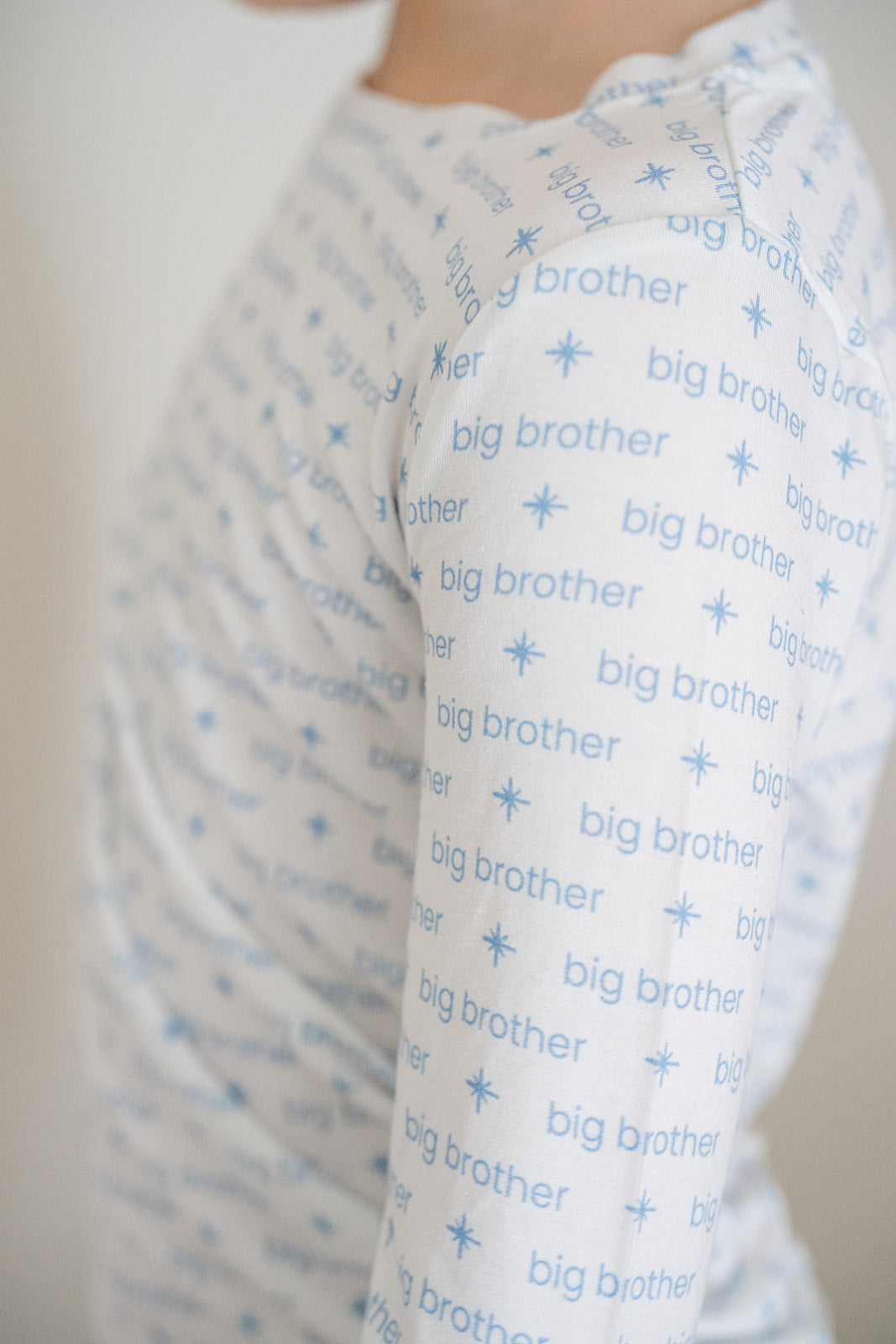 Baby blanket with 'big brother' text and star patterns, wrapped around a person.