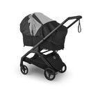 A black and gray stroller with a matching bassinet cover, shown at a three-quarter angle on a clean white background.