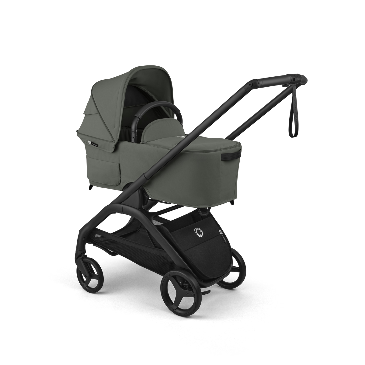 A stroller travel system in muted sage green with a black frame and wheels, shown on a clean white background. The system includes a bassinet attached to a stroller with a long handle and a black storage basket.