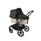 Black baby stroller with beige seat on a white background