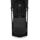 A top-down view of a black stroller with a matching black footmuff, showing the harness straps and the circular logo on the headrest against a white background.