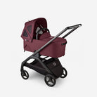Maroon baby stroller with black wheels and handle on a light gray background