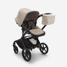 Beige and black stroller with a cup holder on a white background