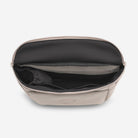 Open beige bag with black interior on a light gray background