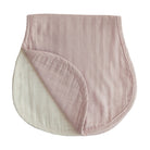 Two organic muslin burp cloths, one in blush and one in fog color, laid out flat.
