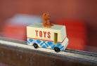Toy truck with 'TOYS' on the side and a teddy bear on top, blurred background