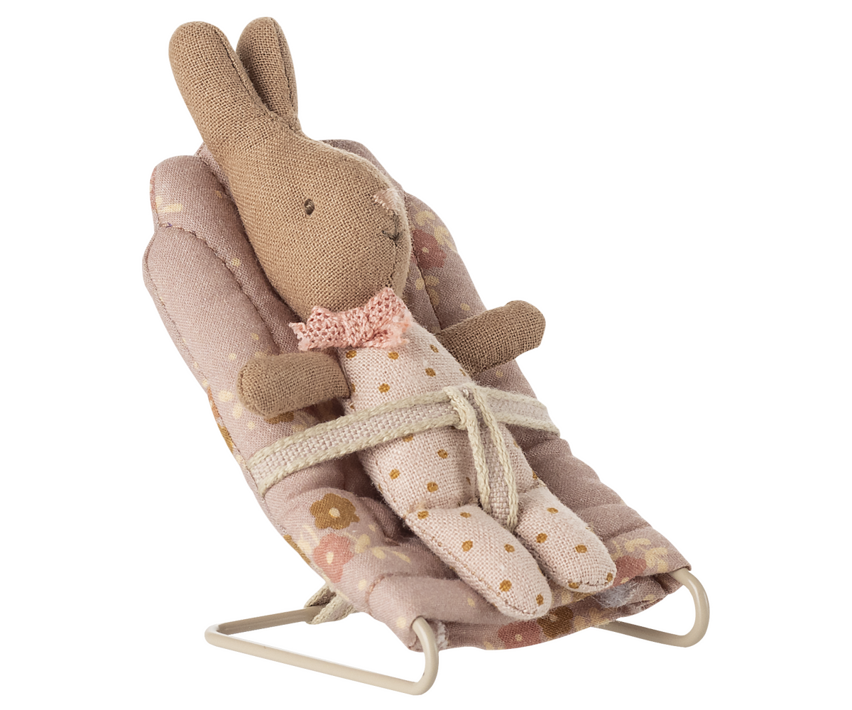 Toy rabbit in a bouncer with a floral pattern on a white background