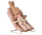 Toy rabbit in a bouncer with a floral pattern on a white background