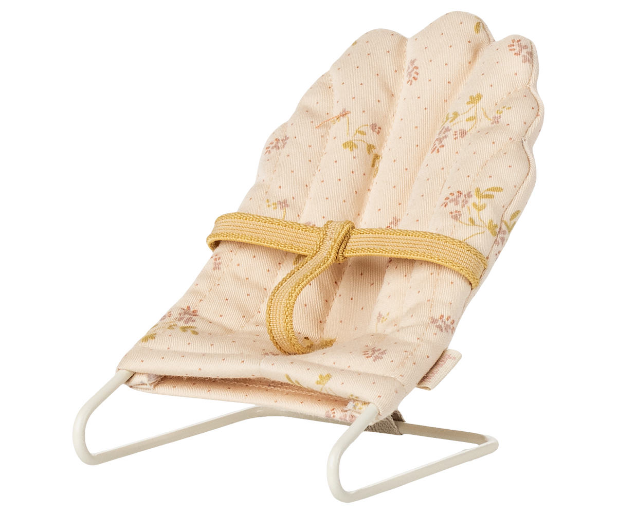 A miniature off-white Maileg micro babysitter bouncy chair with a soft floral patterned fabric seat and a metal wire frame, shown against a transparent checkered background.