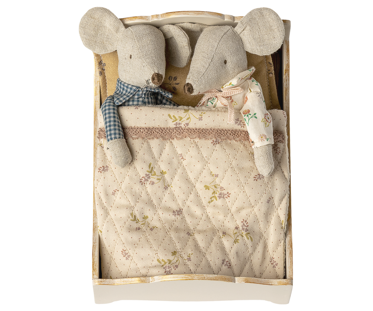 Two plush mice toys in a wooden box with a quilted lid featuring floral patterns.